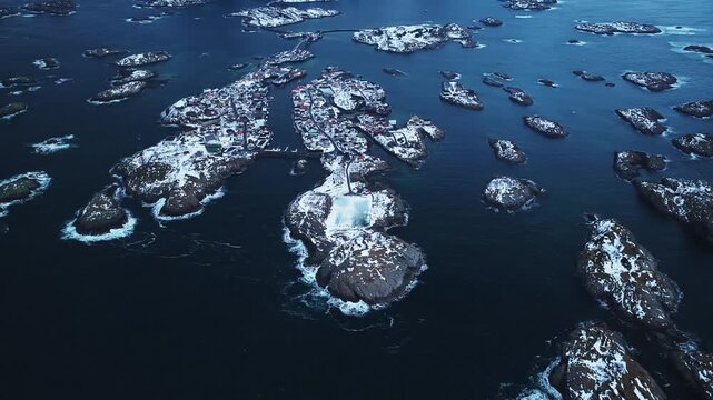 Aerial view of the snow covered islands of Henningsv&aelig;r, with the iconic football stadium standing out against the dark blue waters, Henningsv&aelig;r, Nordland, Norway.