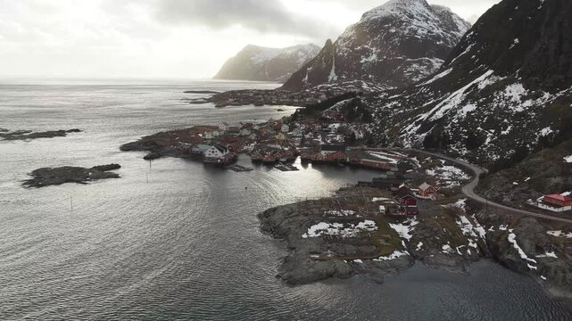 Aerial view of the quaint village of Tind nestled amidst snow-capped mountains and the serene sea, showcasing the stark beauty of the Norwegian landscape, Tind, Nordland, Norway.