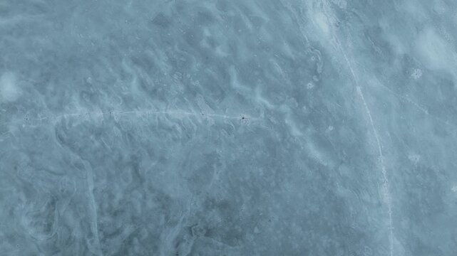 Aerial view of the intricate patterns and textures of a frozen lake creating a mesmerizing winter landscape, Tind, Nordland, Norway.