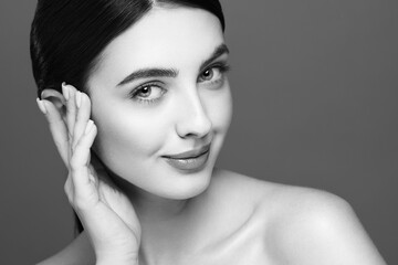 Portrait beautiful young woman with clean fresh skin. Model with healthy skin looks at an empty space, close up portrait. Cosmetology, beauty and spa