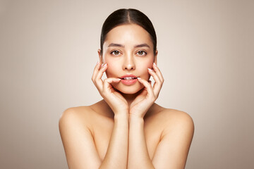 Portrait beautiful young woman with clean fresh skin. Model with healthy skin looks at an empty space, close up portrait. Cosmetology, beauty and spa
