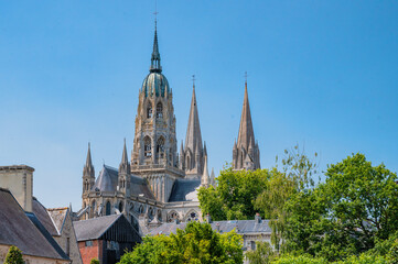 Obraz premium Close view of Bayeux Cathedral spires through trees Normandy