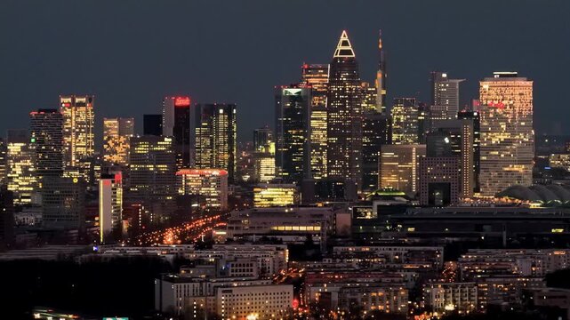 Aerial view of the city's skyline, a symphony of light painting the night as buildings illuminate the urban landscape, Frankfurt, Hessen, Germany.