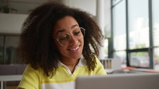 Carefree African American woman smiling looking in laptop typing computer successful e-learning in university high school female student girl studying enjoying internet education in college academy