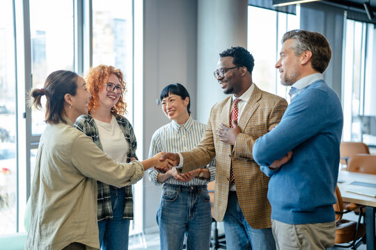 Diverse business professionals shaking hands forming new partnership