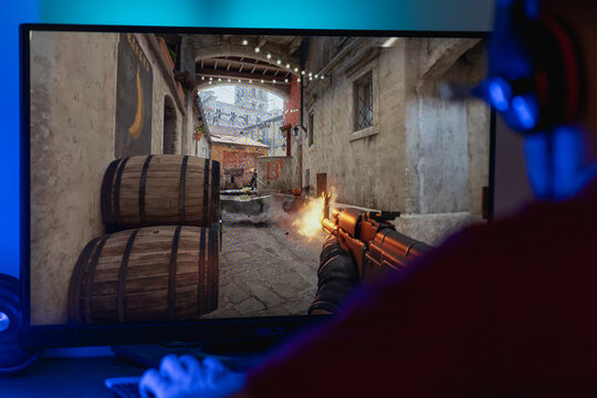 First-person perspective of a gamer playing Counter-Strike 2, showing gameplay action with a firing weapon on the Inferno map, tactical esports and competitive gaming concept.