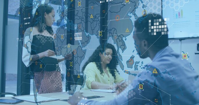 Reviewing curly woman in yellow blouse writing papers at meeting table, with laptop digital overlay