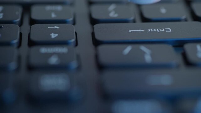 Closeup caucasian fingertip tapping enter, black laptop keyboard, home key visible, muted studio light, steady admin rhythm, methodical office task, macro clarity