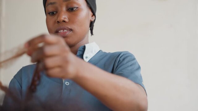 Mid black woman carpenter measuring wood, airy workshop scene, steady hands marking board with tape and pencil, focused posture, preparing joinery and fit, denim shirt collar, vocational skill