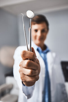 Dentist, hands and tools in clinic with healthcare consultation, dental probe or mirror for procedure. Orthodontics, person and oral excavator in office for equipment, instrument and medical service.
