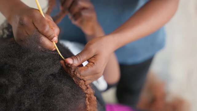 Closeup hands braiding with brown extensions, home braider weaving textured strands, comb and pick tools, apprenticestyle focus, pattern formation and secure finishing for protective style