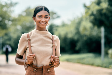 Tourist, portrait or Indian woman in park with bag, adventure or summer travel on weekend vacation. Happiness, stroll or person with backpack, outdoor break or holiday sightseeing in Australia. © peopleimages.com