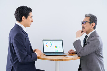 Fototapeta premium ノートパソコンを見ながら打ち合わせをする日本人男性