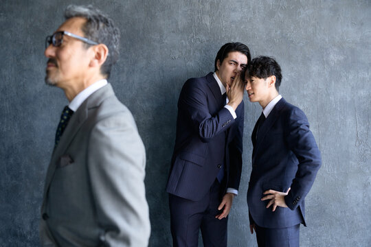 上司の噂話をする日本人男性