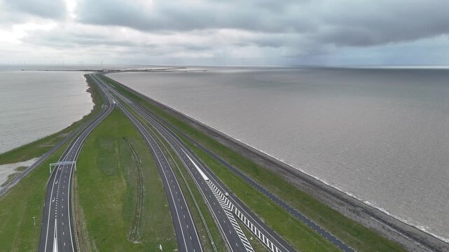 Rising drone view over interchange and distant wind turbines
