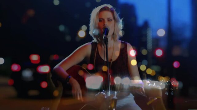 Female singer adjusting grip and leaning toward mic, singing and strumming guitar to engage crowd