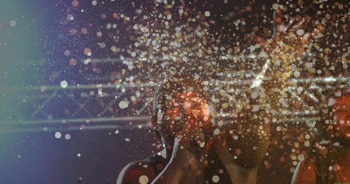 Concert singer holding mic, raising arm as confetti bursting stage obscuring band, hyping crowd