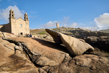 Kidney Stone. Muxía (Spain), March 15, 2026. Tradition attributes healing powers to this stone. In the background, the Sanctuary of Our Lady of the Boat. 