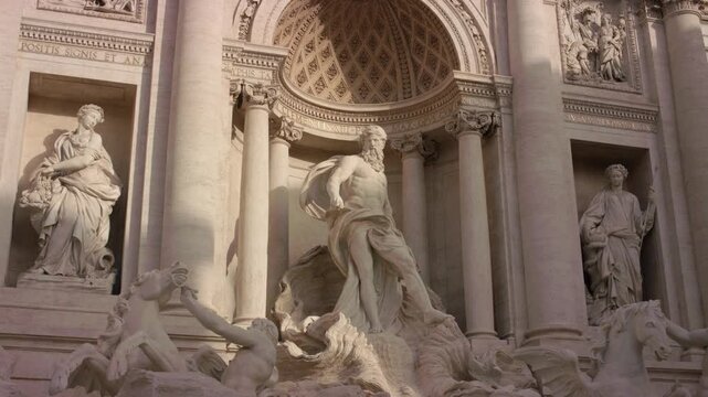 Trevi Fountain in Rome featuring Oceanus statue with surrounding baroque sculptures and cascading water creating iconic historic landmark scene in Italian city