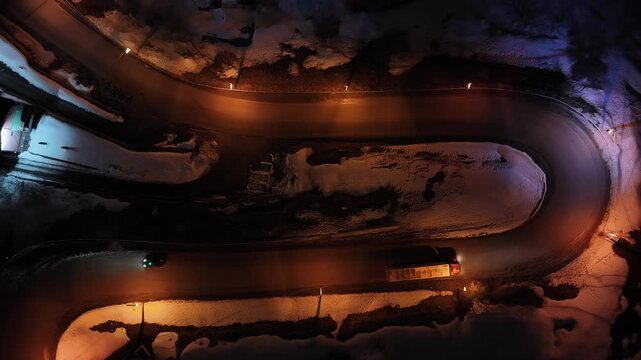Night Drone view of Gudauri in Georgia town with snow covered mountains, ski slopes and town after fresh snowfall in winter season. Gudauri ski resort with fresh powder snow, Georgia.