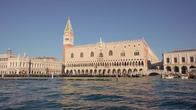 Doge Palace and St Mark Campanile in Venice seen from water with gentle waves and historic architecture creating iconic waterfront city scene from boat perspective