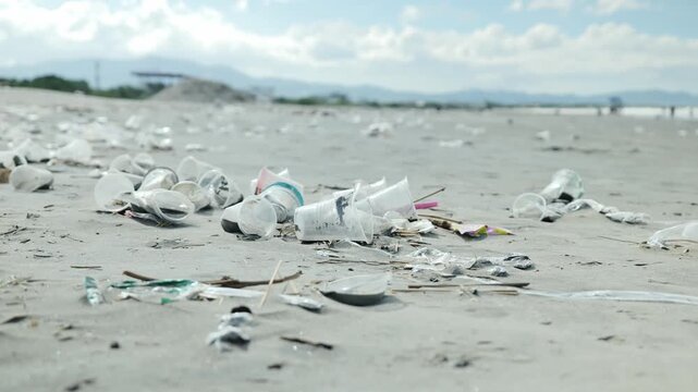 Plastic waste covers Lingayen coast as light wind moves debris under grey skies