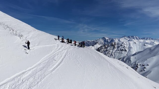 Freeride skiers climbing and descending Bidara peak in Gudauri on deep fresh powder snow, winter adventure in Georgia mountains. Backcountry freeride and skiing untouched powder in snowy mountains.
