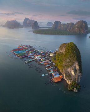 Aerial view of the colorful floating village of Ko Panyi built on stilts beside a giant limestone cliff in Ao Phang Nga National Park Tambon Ko Panyi, Chang Wat Phang-nga, Thailand.