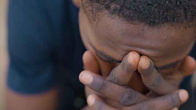 Black carpenter inspects hands with dust, closeup view of palms and fingers, workshop background, concentrated expression, planning repair steps and measuring next move, tense but determined mood