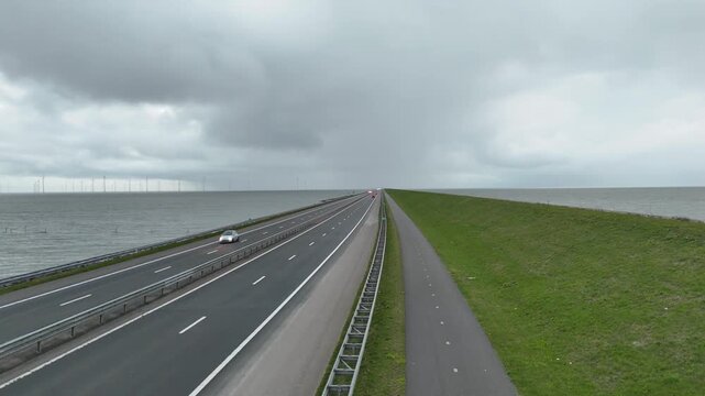 Vertical rise above endless dam fading into cloudy horizon