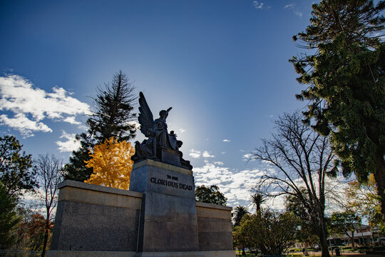 Angel statue memorial to the glorious dead under a bright blue sky with sun flares