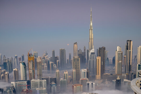 sunrise of fog and clouds below the dubai skyline from a high vantage point 