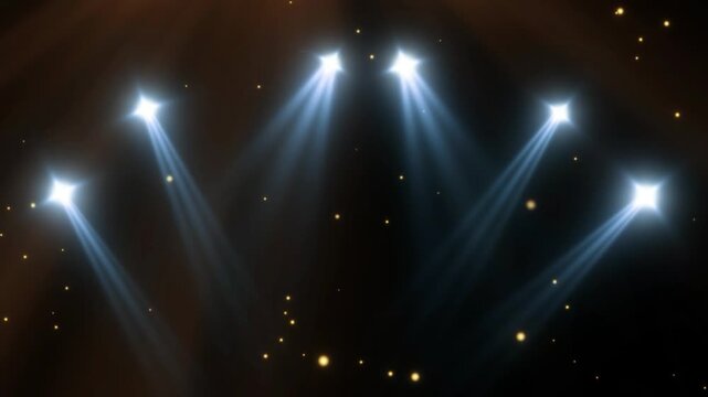Five bright stage lights shining down on a dark background with small yellow dots