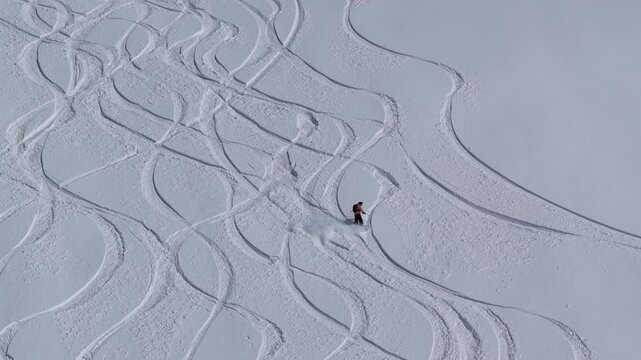 Freeride skiers climbing and descending Bidara peak in Gudauri on deep fresh powder snow, winter adventure in Georgia mountains. Backcountry freeride and skiing untouched powder in snowy mountains.