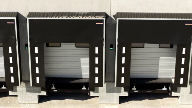 Aerial view of industrial loading docks featuring a contrast of dark canopies and light doors, creating a geometric pattern, Doncaster, England, United Kingdom.