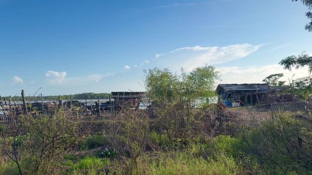 Cinematic 4K aerial view of the famous abandoned Twin Houses in Thale Noi wetlands with white birds sitting in water near Chaloem Phra Kiat road bridge in Phatthalung Thailand at daytime