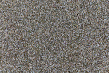 Fototapeta premium Close up of small light pebbles embedded in surface creating a uniform granular texture.