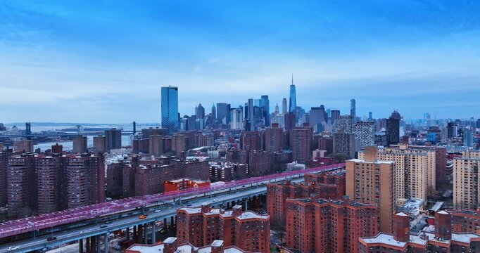 Flight over the red brick blocks of flats in New York, USA. Approaching the highway leading to and from the Williamsburg Bridge at dusk.