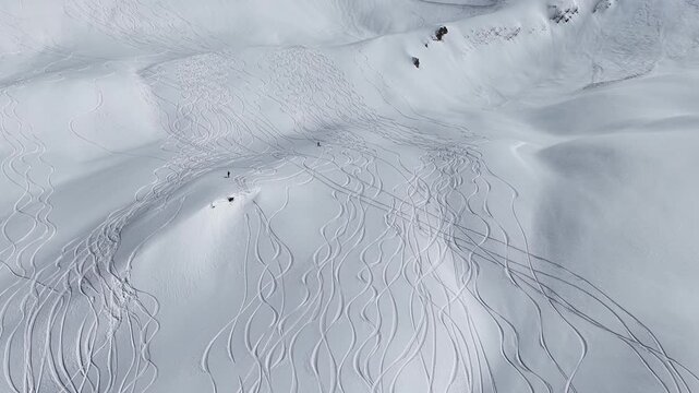 Freeride skiers climbing and descending Bidara peak in Gudauri on deep fresh powder snow, winter adventure in Georgia mountains. Backcountry freeride and skiing untouched powder in snowy mountains.