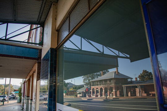 Reflection of historic Australian Post Office building in shop window on a sunny day