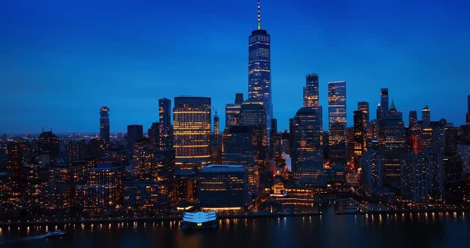 Moving over the waterscape along the waterfront with gorgeous skyline. Motor boat moves by the river. New York, USA at night.