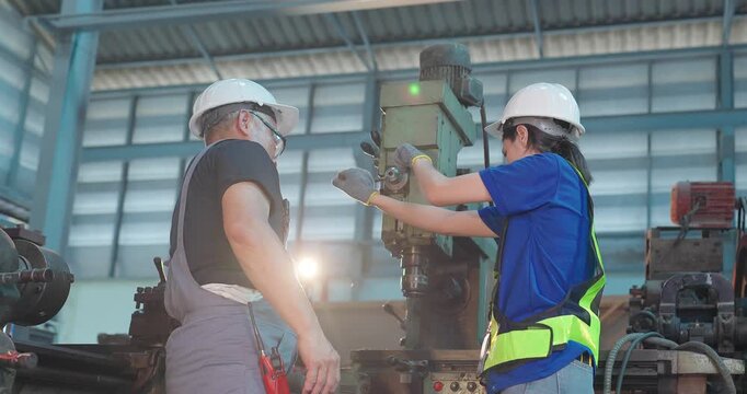 Father passes down machine know-how to his daughter in a family factory, guiding succession, workshop skills and leadership transition through hands-on manufacturing training.
