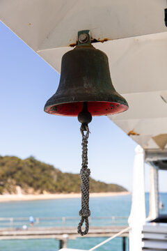 large bell on a barge with K'gari in the background