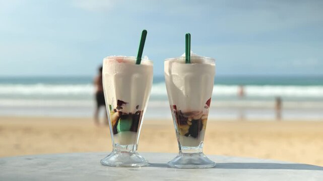 Cold Filipino halo halo dessert served by beach with ocean waves behind