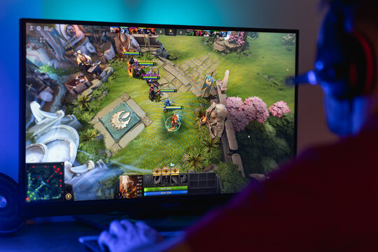 Gamer playing Dota 2 on a computer monitor, showing strategic MOBA gameplay with hero character and map interface, esports and competitive online gaming concept.