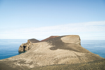 Volcanic crater cone formation with turquoise ocean backdrop © Daniel