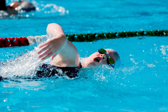 Girl racing/ training competitive freestyle, taking a breath