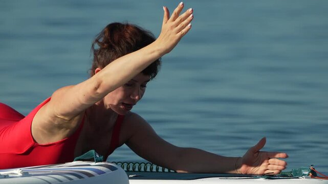 Woman, paddleboarding, water, doing exercise on a sunny summer day