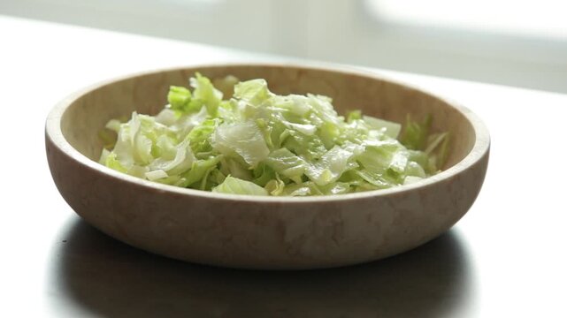 Preparing fresh salad with iceberg lettuce, green apple sticks, and creamy Dijon mustard dressing