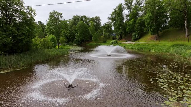 Tranquil river scene, fountains and greenery, park atmosphere, Dobele, Latvia